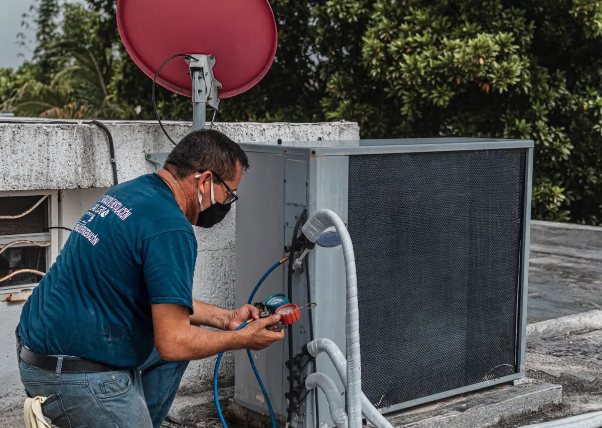 Technician checking refrigerant pressure with a manifold gauge